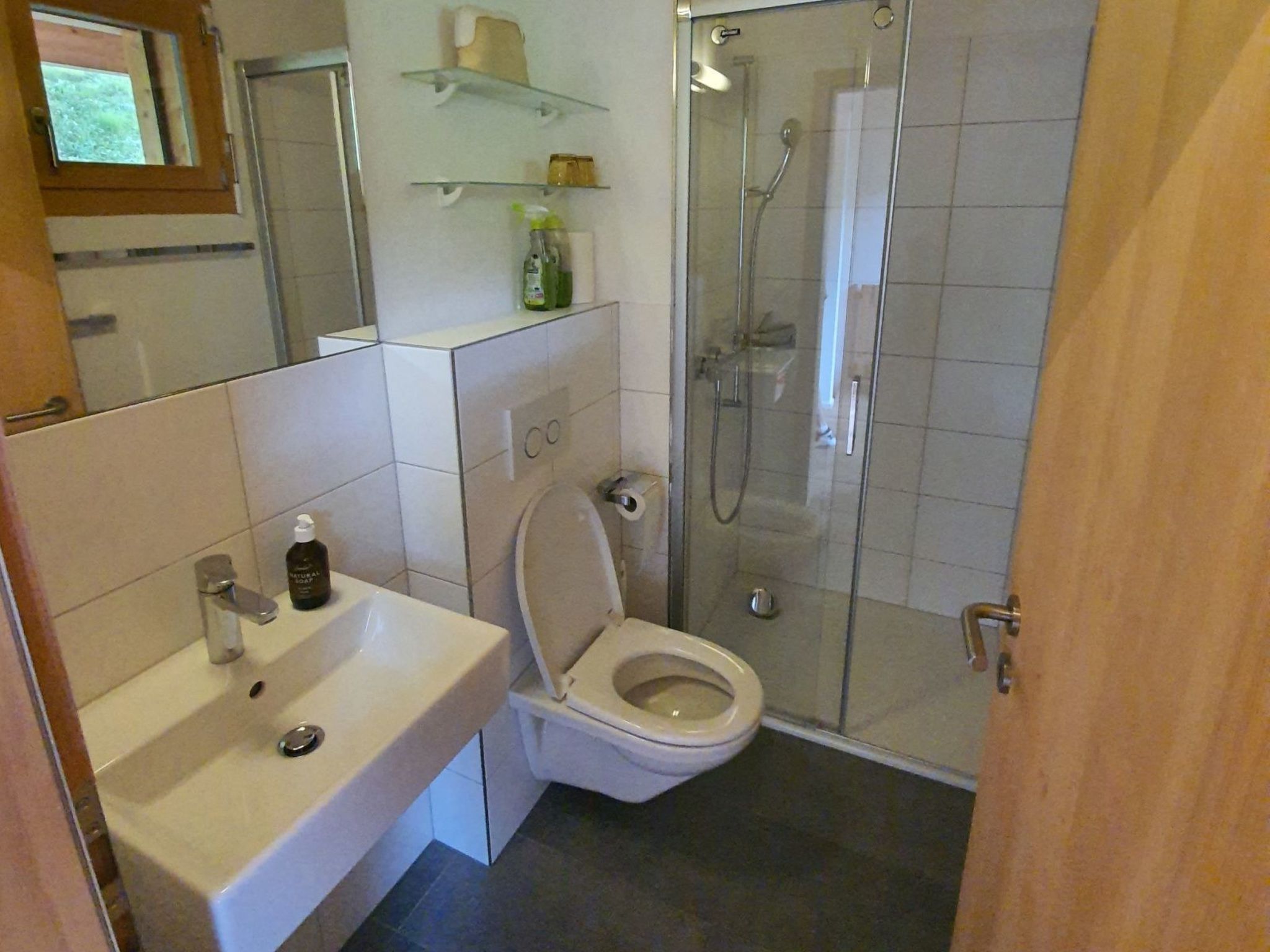 A bathroom with a toilet, sink, and shower.