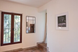 Ein Flur mit einer Holztür, einem Spiegel und einem gerahmten Bild an der Wand.
