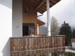 A wooden deck with a white wall and a wooden roof structure. - Crest Grond Herter, Waltensburg, (Waltensburg/Vuorz), 58006B by Interhome (Vuorz)