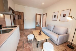 Ein moderner Wohnraum mit einer Küche, einem Sofa und einem Esstisch.