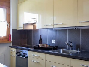 Eine moderne Küche mit einem eingebauten Backofen, einem Spülbecken und einem Fenster.