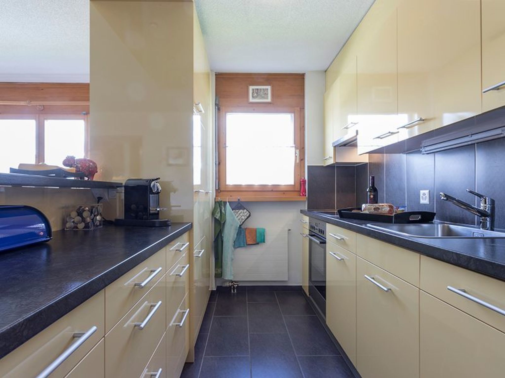 Una cocina compacta con ventana, un tostador y un lavamanos.
