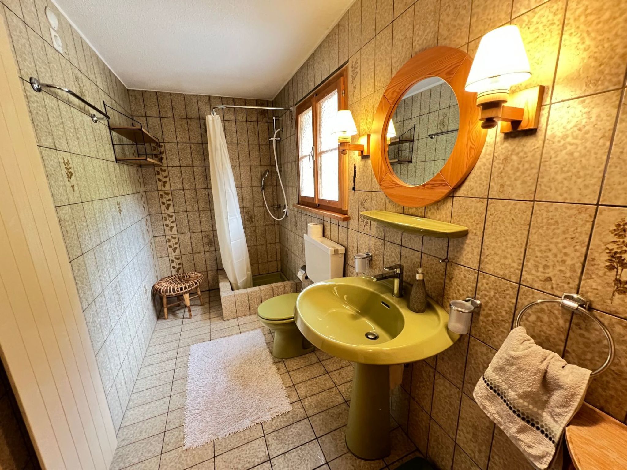 Ein Badezimmer mit Dusche, Toilette, Waschbecken und Handtuchhalter.