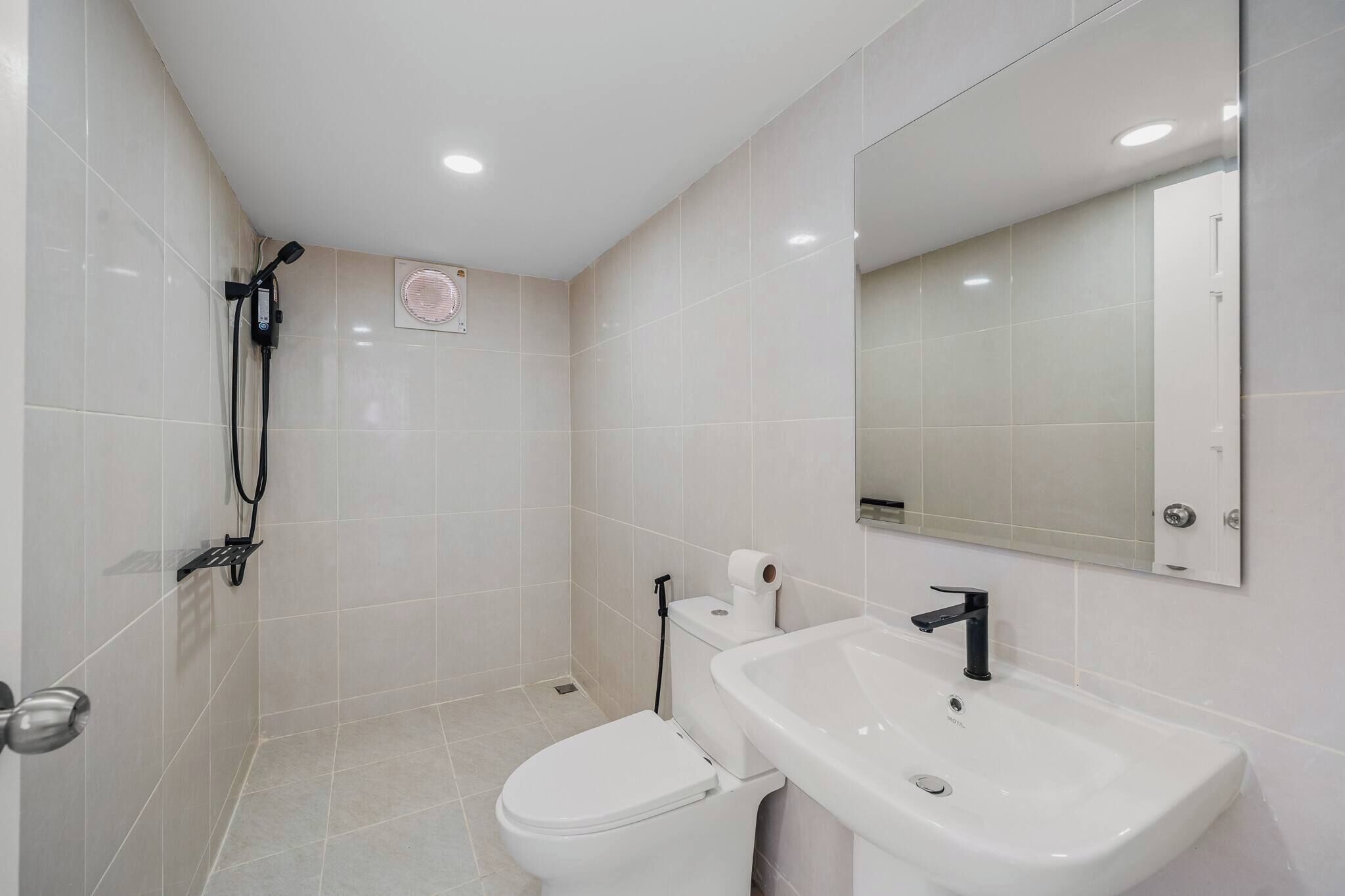 A modern bathroom with a toilet, sink, and shower.