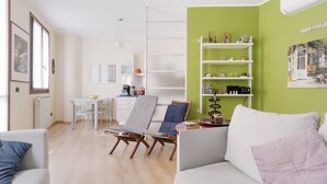 Un salon avec un canapé, une table à manger et une bibliothèque.