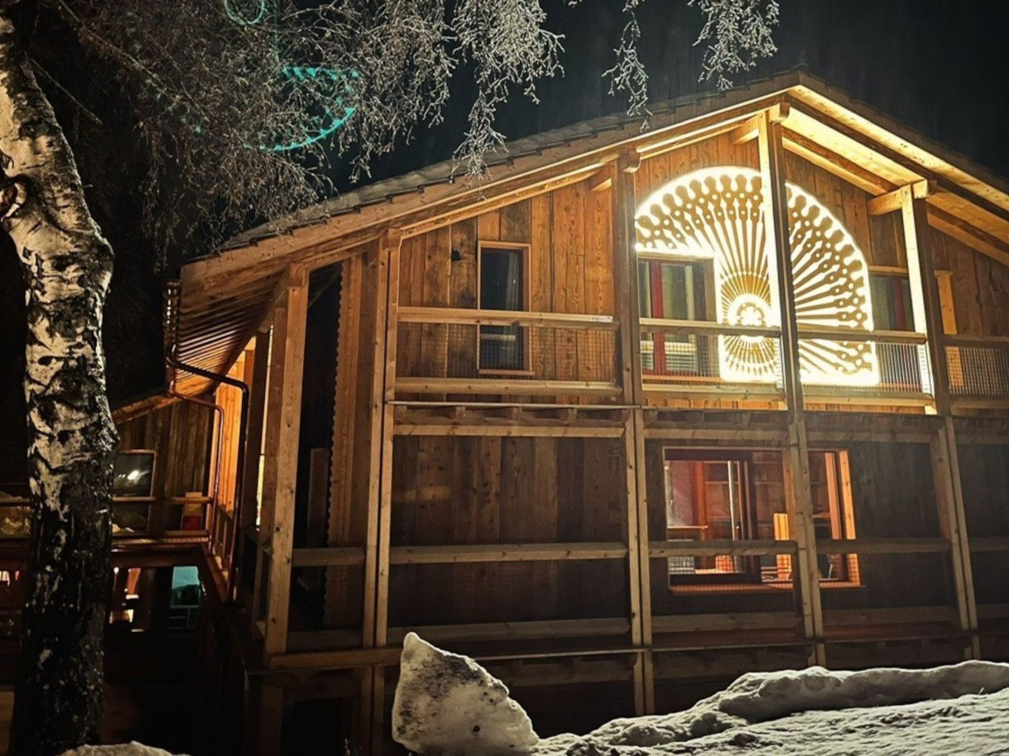 A wooden cabin with a large circular window and a balcony.