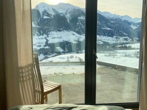 Une pièce dotée d’une grande fenêtre donnant sur un paysage montagneux enneigé.