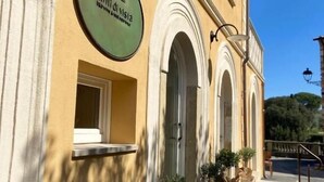 A building with a sign reading 'Puntieri di vista' and a small window. There are potted plants and a staircase leading to the entrance.