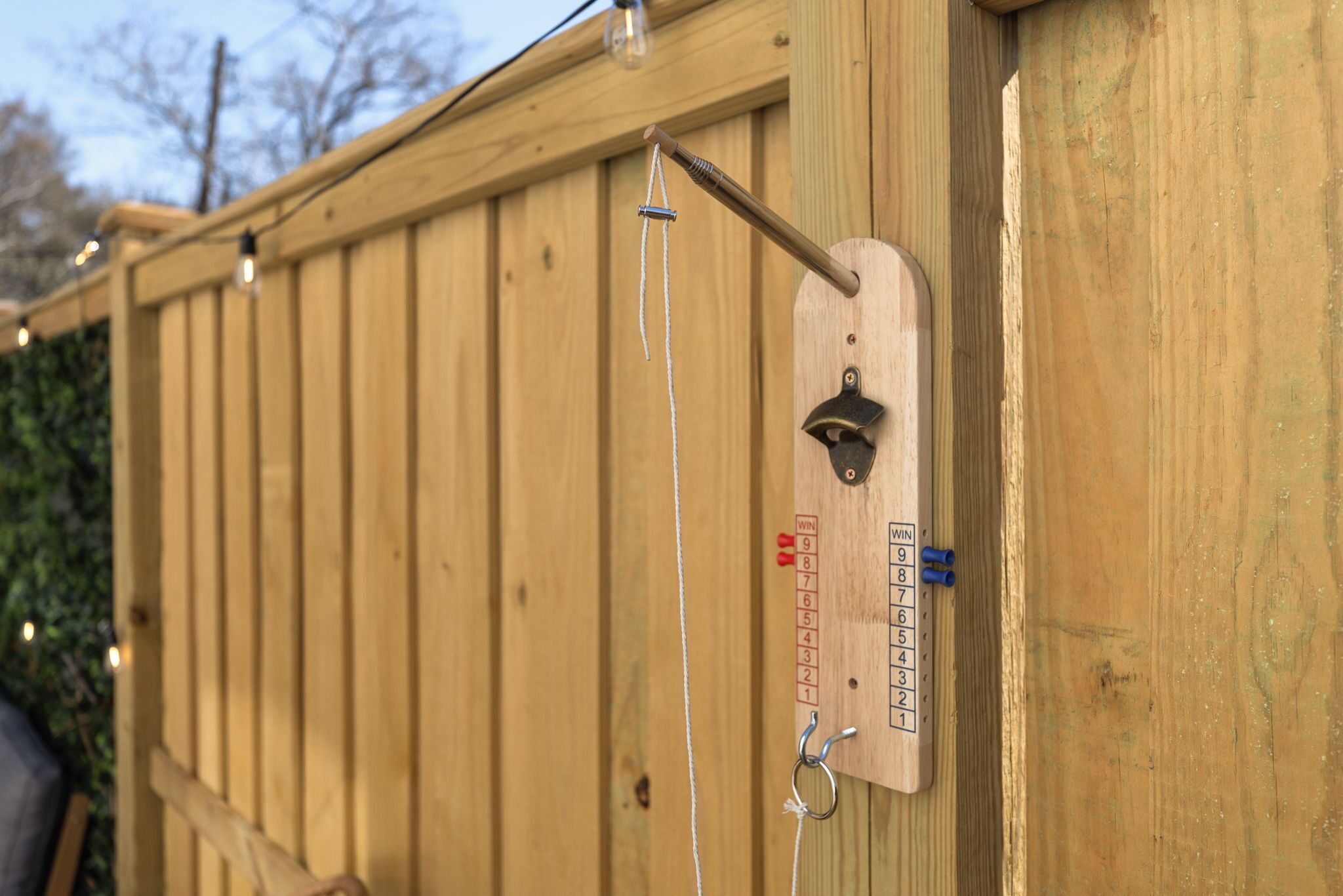 A wooden fence with a metal plaque displaying a winch and a winch scale.