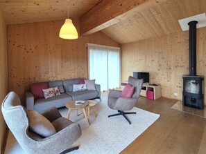 Una sala de estar acogedora con un sofá, sillones, una mesa de centro y una chimenea.