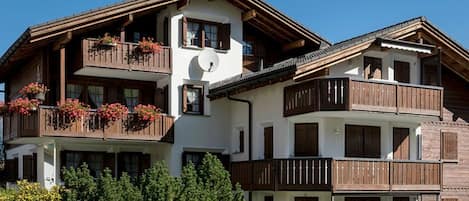 Un immeuble à plusieurs étages doté de balcons, de rampes en bois et de jardinières.