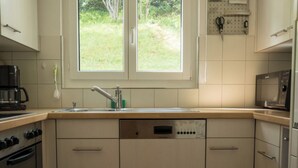 Una cocina equipada con lavavajillas, estufa y microondas.