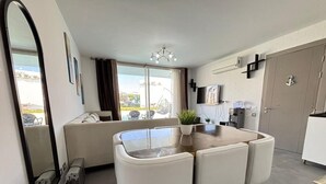 A modern kitchen with a dining area, a large mirror, and a sliding glass door to the outside. - Fouka North Coast CL3-TW3X-A-G (Marsa Matrouh)