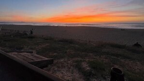 A beach with a sunset, a wooden structure, and a fence. - Elegance & Terrace in the heart of the 5 Cantons - Beaches on foot (Anglet)