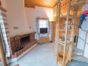 A room with a fireplace, a television, and a wooden climbing structure. - Casa Panorama Kuhn, Brigels, (Breil/Brigels), 65060B by Interhome (Breil/Brigels)
