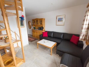 A living room with a black sofa, a wooden coffee table, a wooden cabinet, and a staircase. - Casa Panorama Kuhn, Brigels, (Breil/Brigels), 65060B by Interhome (Breil/Brigels)