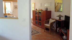 A living room with a sofa, a wooden cabinet, a television, and a painting on the wall. - Gadahüs Elvers, Obersaxen-Misanenga, (Obersaxen), 34091B by Interhome (Obersaxen Affeier)