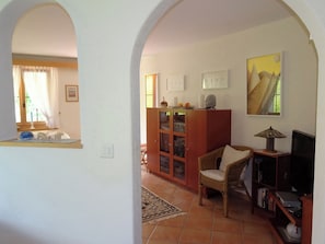 Un salon avec un canapé, un meuble en bois, une télévision et un tableau accroché au mur.