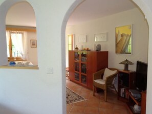 Ein Wohnzimmer mit Holzschrank, Fernseher und Sessel.
