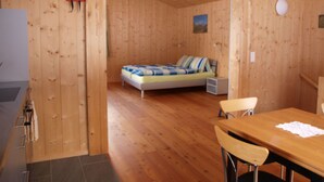 Un interno in legno con un letto, un tavolo da pranzo e sedie.