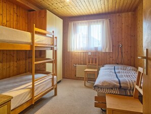 A wooden room with bunk beds, a desk, and a chair. - Genoveva Sax, Obersaxen-Meierhof, (Obersaxen), 34065B by Interhome (Obersaxen Affeier)