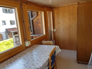 A small room with a bed, a window, and a wooden wardrobe.
