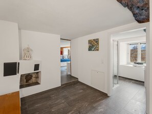 A hallway with a radiator, a white wall with a picture, and a window with a view. - Pacifica und Romantica in Cumpadials, (Cumpadials), 76002B by Interhome (Cumpadials)