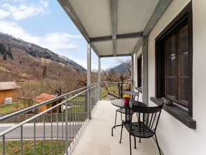 A balcony with a table and chairs, overlooking a mountainous landscape. - Pacifica und Romantica in Cumpadials, (Cumpadials), 76002B by Interhome (Cumpadials)