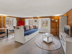 Ein kompakter Wohnraum mit Bett, Essbereich, kleiner Küche und Fernseher.