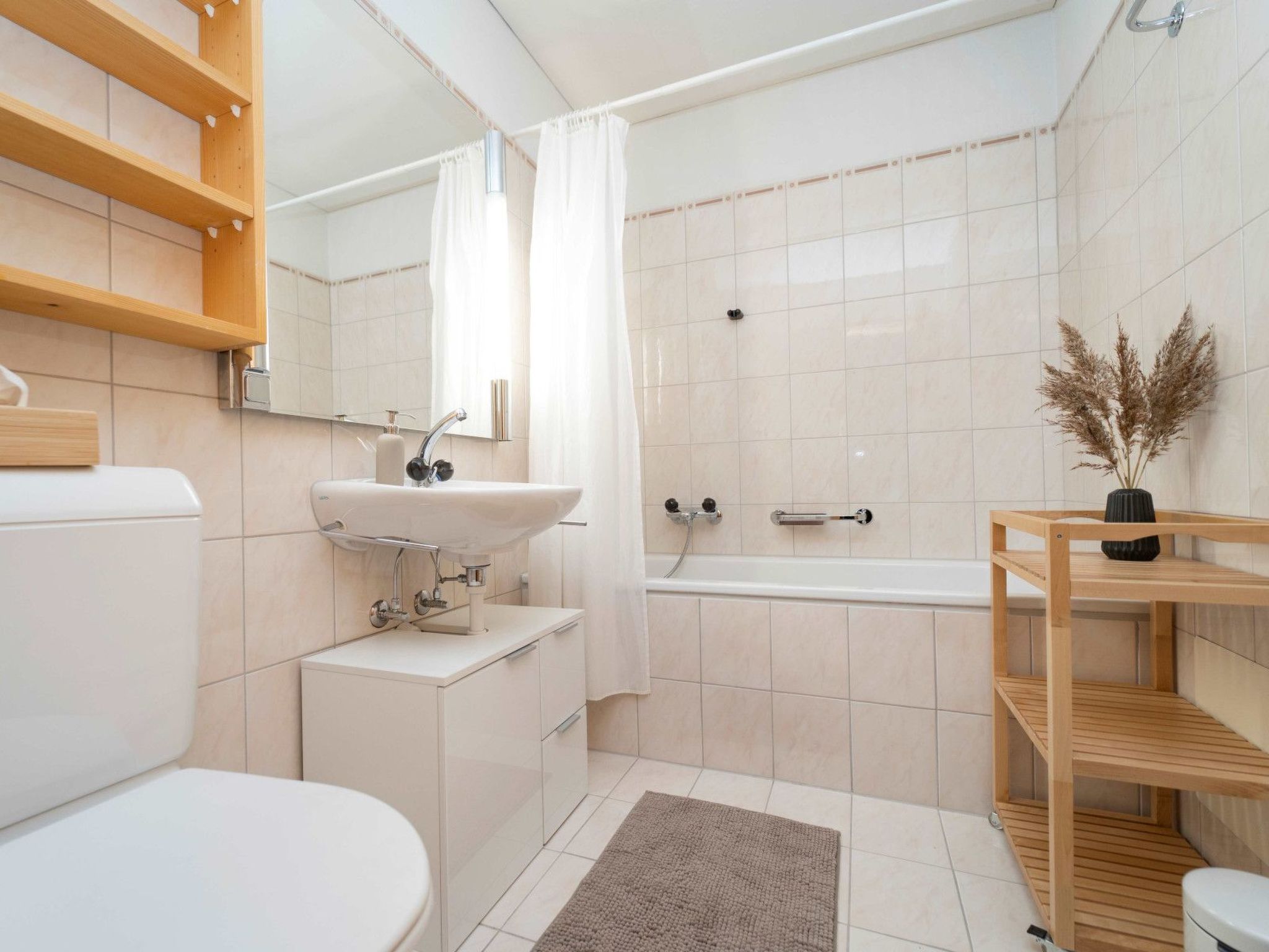 Ein modernes Badezimmer mit Toilette, Waschbecken, Dusche und Badewanne.