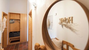 Una habitación con un armario de madera, un espejo y una cama con cabecero de madera.