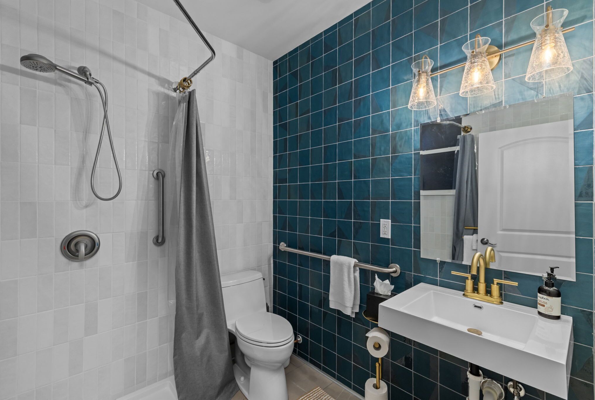 Une salle de bain moderne équipée d’une douche, de toilettes, d’un lavabo et d’un porte-serviettes.