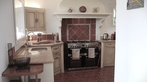 Una cocina con estufa, lavabo y armarios.