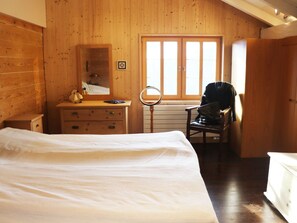 Ein Schlafzimmer mit einem Bett, einem Schminktisch, einem Spiegel und einem Fenster.