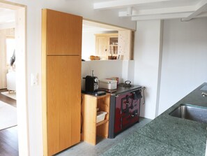 A compact kitchen with wooden cabinets, a built-in stove, and a sink.