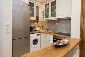 A modern kitchen with stainless steel appliances, wooden countertops, and white cabinetry. - Lovely 1 Bd Apt with Balcony 10 min from Acropolis (Athina)