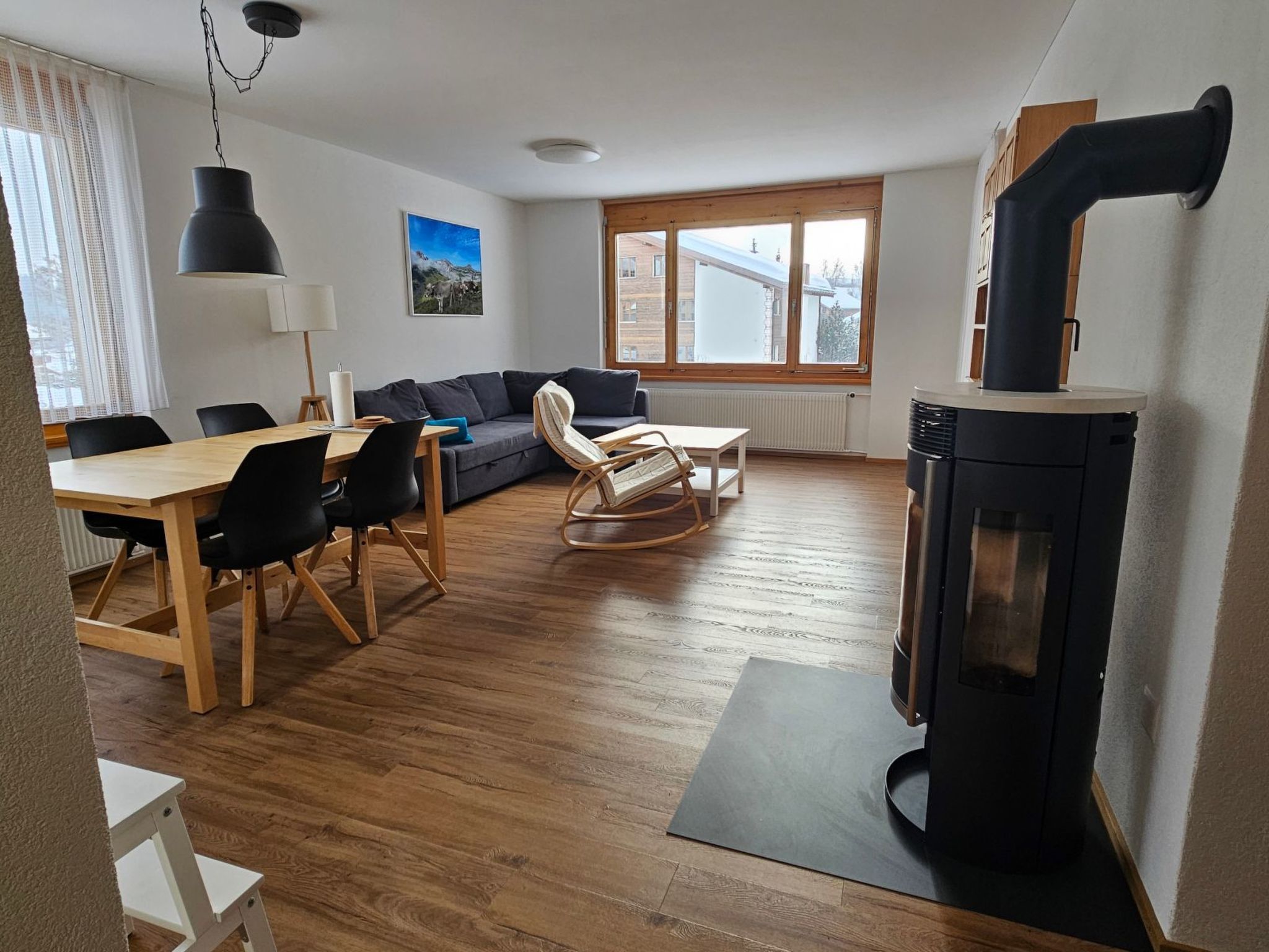Ein gemütliches Wohnzimmer mit einer Couch, einem Esstisch und einem Kamin.
