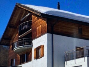 A two-story building with a wooden facade and a balcony. - Haus Vicasa, Andiast, (Andiast), 59003B by Interhome (Andiast)