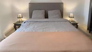 A bedroom with a bed, two bedside tables, and a ceiling light fixture. - Sea & Elegance in the 8th district - Prado beaches on foot & garden terrace (Marseille)