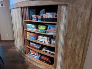 A wooden bookshelf with various board games and board game boxes. - Stay and Play in Groveland - EV charging - 40 minutes to Yosemite Gate (Groveland)