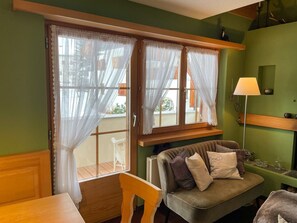 Une pièce avec un canapé, une table et une lampe.