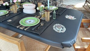 Un comedor con pared de piedra, un mosaico y una mesa dispuesta para una comida.