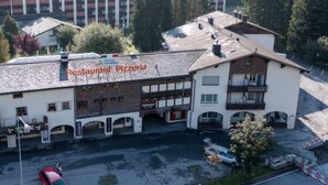 A building with a sign reading 'Restaurant Pizzeria' and a red car parked in front. - Cristallina A2 by Interhome (Laax)