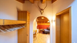 A hallway with wooden doors, a coat rack, and a deer skull on the wall. - Casa la Streila by Interhome (Laax)