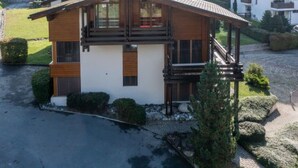 A two-story house with a wooden facade, large windows, and a balcony. - Casa la Streila by Interhome (Laax)