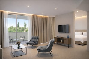 A modern hotel room with a balcony, a bed, a TV, and two armchairs. - Elitis House Suite & Spa (Nova Milanese)
