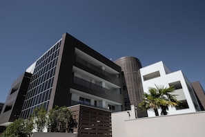 A modern building with a flat roof, multiple balconies, and a cylindrical structure. - Elitis House Suite & Spa (Nova Milanese)