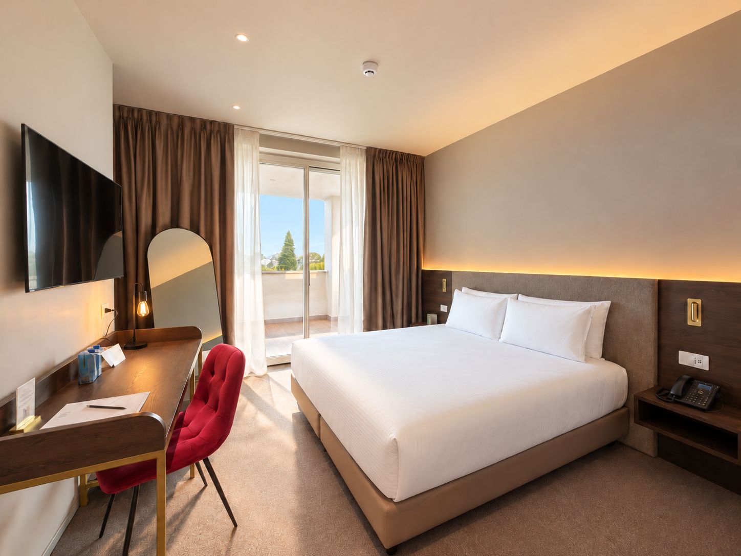 Une chambre d’hôtel équipée d’un lit, d’un bureau, d’une chaise et d’un téléviseur.