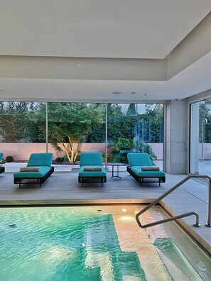 A modern outdoor pool area with three lounge chairs and a small table. - Elitis House Suite & Spa (Nova Milanese)