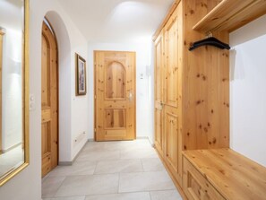 A hallway with wooden doors and a bench. - Runca 752 by Interhome (Flims)
